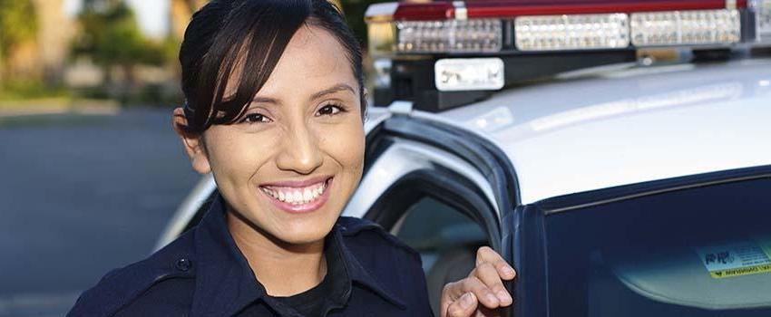 微笑的女警察站在她的车前