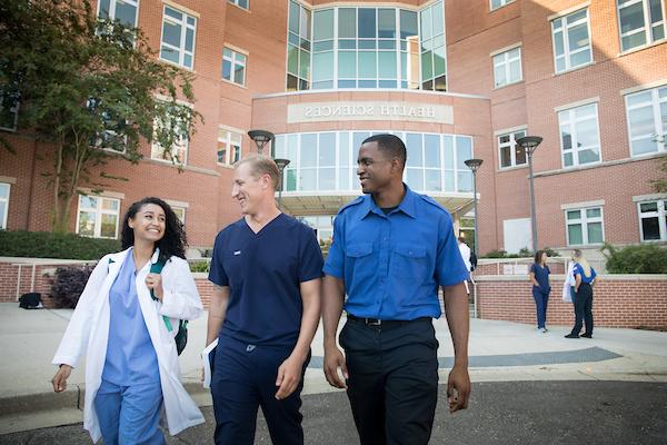 三个专职医疗专业的学生走出大楼.
