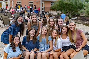 学生 smiling in a group at the outdoor deck of the campus rec center.