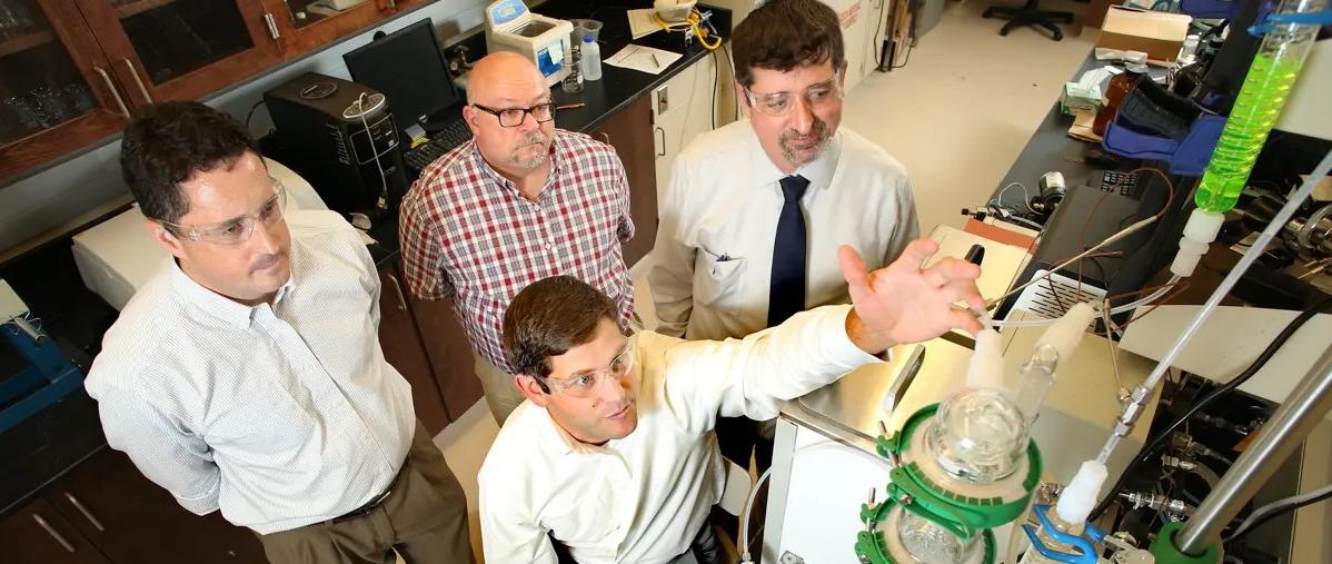 左至右:马修·赖切特，格兰特·格洛弗(坐)，詹姆斯·戴维斯，凯文·韦斯特在实验室.
